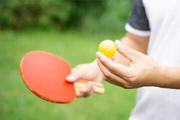 Man is playing table tennis outdoor. Concept : Sport with equipment, workout. Recreational sport...
