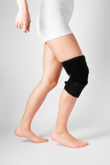 Knee Support Brace on leg isolated on white background. Elastic orthopedic orthosis. Anatomic...