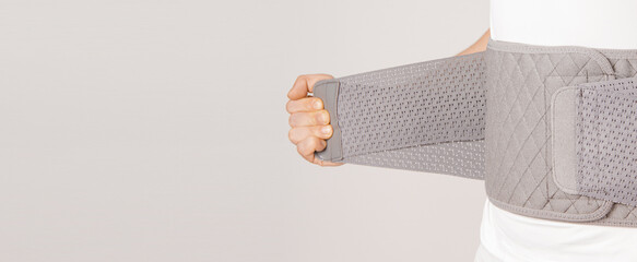 Lumbar brace on the human body isolated on a white background. Trauma of back. Back brace,...