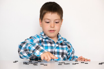 A 4-year-old boy is learning to count, teaching black numeracy chips for preschoolers