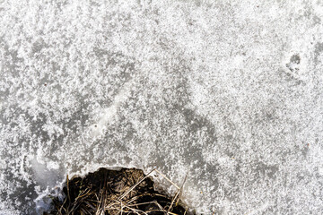 Spring ground covered with thawing snow