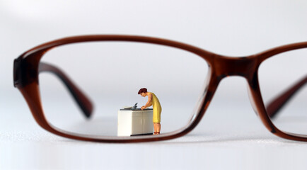 The concept of social prejudice against women. Business concept with glasses and miniature people.
