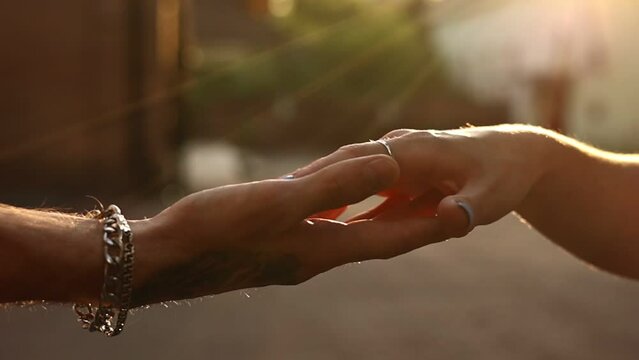 hands of romantic couple a close-up. hands men and women symbol love teamwork sunlight happy family together. silhouette hands support stroking each other. dating, romantic atmosphere.