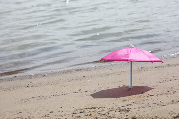 beach umbrella in sand on a beach near water