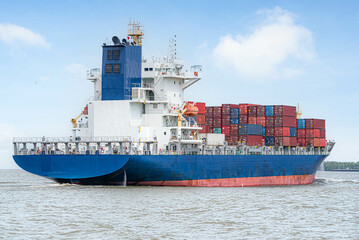 A large cargo ship, carrying a large number of containers floating in the middle of the sea, to transportion and import-export concept.