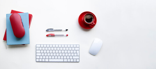 White keyboard and mouse with red and black pens, cup of coffee, notebooks on white table - 517161602