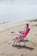 two chaise longues on a beach near waterline
