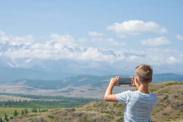 Young boy take photo mountains. Empty space for text