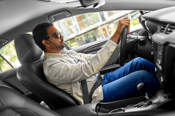 transport, vehicle and people concept - indian man or driver in sunglasses driving car