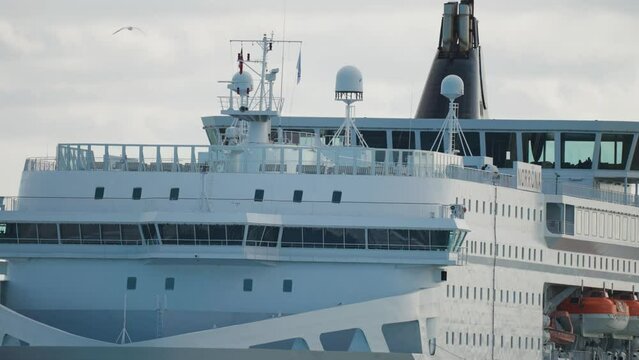 A close-up shot of the massive cruise ship. Slow-motion, pan follow.