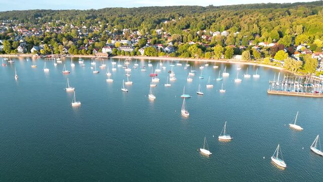 Boats tied up at lake. Sailboats anchor in harbor. Aerial view flying drone of town Herrsching at Ammersee lake, popular excursion and recreation place near munich in bavaria, germany