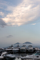 Luxury boats in harbor on a summer evening with Mount Vesuvius in the background, Naples, Italy