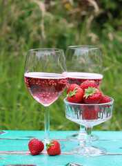 Romantic date in a park. Glasses with cocktails on a table. Refreshment concept. 
