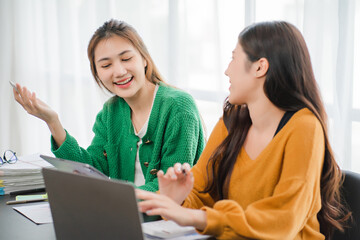 Two beautiful young asian businesswoman working together using digital tablet at office