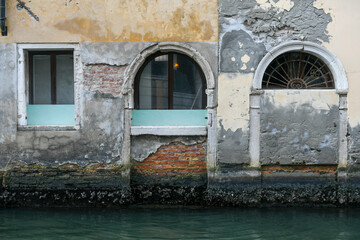 Brick wall with windows over canal in Venice, Italy