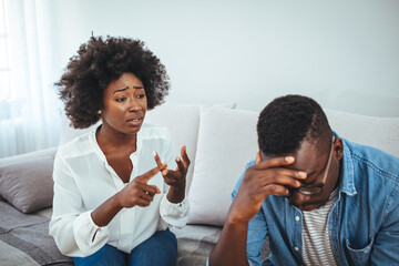 Emotional annoyed stressed couple sitting on couch, arguing at home. Angry irritated nervous woman man shouting at each other, figuring out relations, feeling outraged, relationship problems concept. - obrazy, fototapety, plakaty