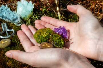 Space with feathers and crystals in the forest. Alternative medicine or esoteric background. Female...