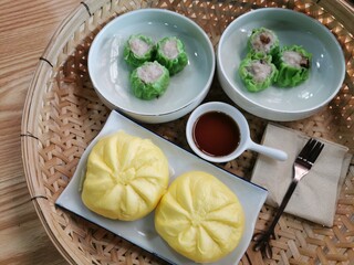 Steamed dumplings and steamed buns in woven bamboo tray