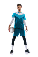 Portrait of young man, volleyball player posing in uniform isolated over white studio background....