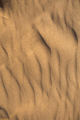 Texture of sand in the desert close-up background. A dune with a pattern of sand waves