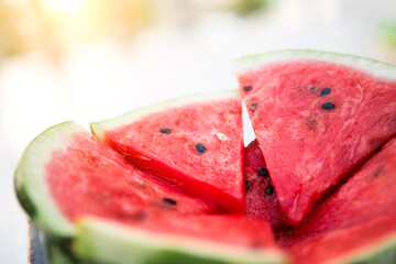 Juicy bright red pieces of sliced watermelon on a black table background.