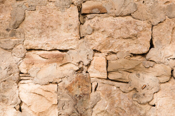 Masonry walls of natural sand color. Stone texture close-up, construction and mining background.