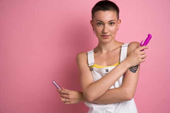 Short haired girl standing with two vibrator for clitoral vaginal stimulation
