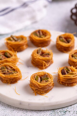 Bulbul Kadayif with Pistachio. Kadayif baklava with pistachio filling on a stone floor. Turkish cuisine desserts. Close-up. local name Antep Fıstıklı Bülbül Kadayıf