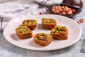 Pistachio kadayif dessert. Kadayif baklava with pistachio filling on a stone floor. Turkish cuisine desserts. Close-up. local name fıstıklı kadayif