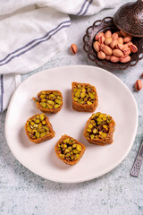 Pistachio kadayif dessert. Kadayif baklava with pistachio filling on a stone floor. Turkish cuisine desserts. Close-up. local name fıstıklı kadayif
