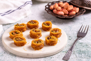 Bulbul Kadayif with Pistachio. Kadayif baklava with pistachio filling on a stone floor. Turkish cuisine desserts. Close-up. local name Antep Fıstıklı Bülbül Kadayıf