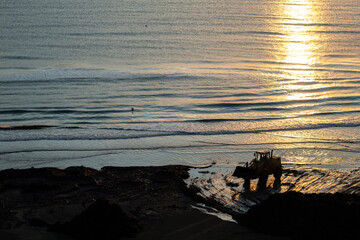Beautiful sunrise with a tractor silhouette working near the sea in Cyprus