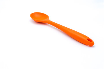 big plastic orange spoon on white background