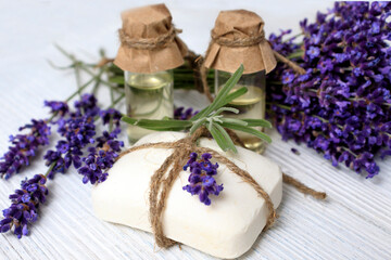 Obraz na płótnie Canvas Natural glycerin lavender soap and lavender oil on a wooden background. The concept of making cosmetic products at home
