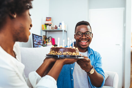Young African American couple celebrating a private and simple birthday event at home. Shot of a young couple having cake while celebrating a birthday at home