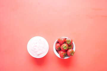 Yogurt and strawberry in a bowl on white 