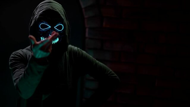 The creepy face of a witch woman is a mask of a mystical girl in a dark world. A gothic cruel woman with evil eyes.