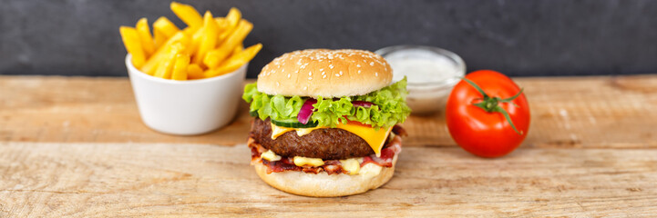 Hamburger Cheeseburger meal fastfood fast food with French Fries on a wooden board panorama