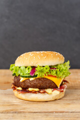 Hamburger Cheeseburger fastfood fast food on a wooden board portrait format