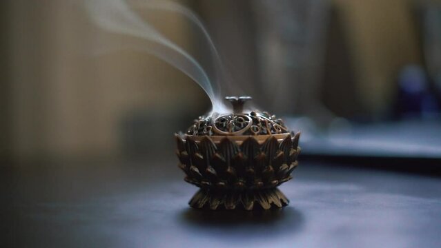 Close up aromatic incense burning on ancient coptic metal artwork. Smoke therapy concept. High quality 4k footage