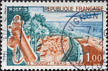 FRANCE - circa 1962: a postage stamp from FRANCE, showing seaside town with beach and golf bag in...