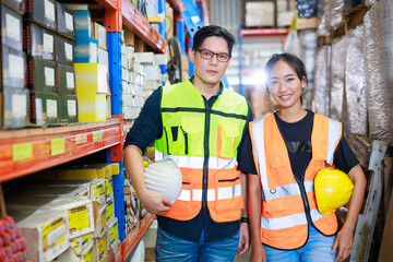 Portrait Asian male and female warehouse worker checking order stock. Professional industrial warehouse team working at store workplace. Unity and teamwork concept.