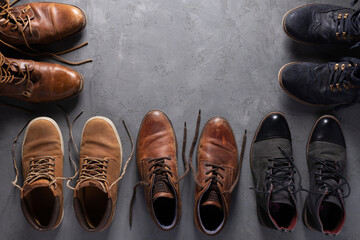 Old leather boots on  cement floor background texture. Old shabby boot shoes