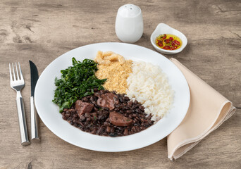Typical brazilian feijoada with rice, pepper, farofa, kale and cracklings