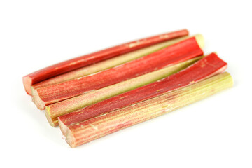 Stems of red-green rhubarb on a white background, selective focus.