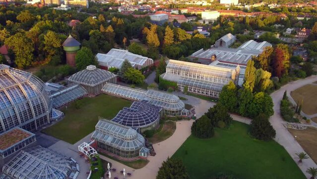 glasshouses greenhouses buildings.
Breathtaking aerial view flight tracking shot from above drone footage, botanischer garten Berlin Lichterfelde, golden hour Summer 2022. Cinematic by Philipp Marnitz
