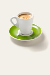 Simple cup of expresso with a green saucer, isolated on white