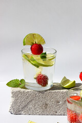 Carbonated drink with lime slices and strawberries in glasses decorated with mint leaves