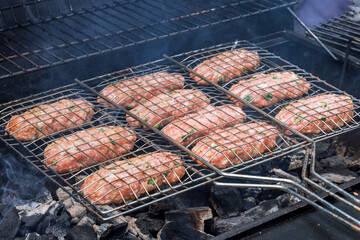 Mixed American barbecue food on a hot grill with burgers beef roasts