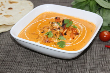Butter Chicken served in a dish isolated on wooden background side view of Pakistani food
